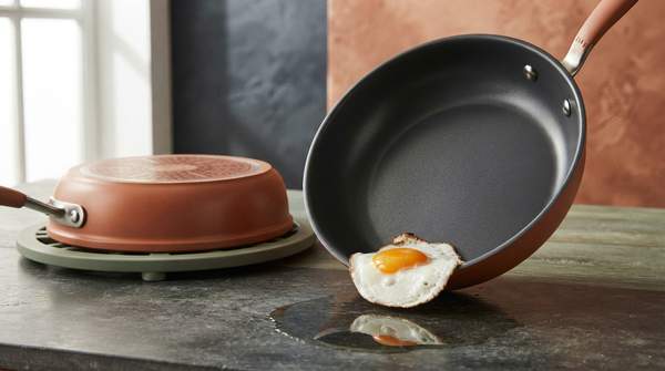 Editorial illustration for PTFE, Ceramic, or Seasoned Metal: Which Non-Stick Pan Fits How You Cook